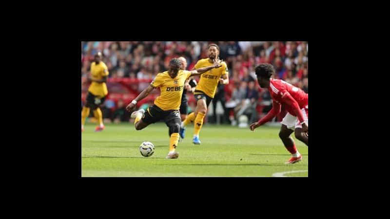 Cầu thủ đội Wolves với chiếc áo màu vàng đang tranh chấp quả bóng với cầu thủ đội…